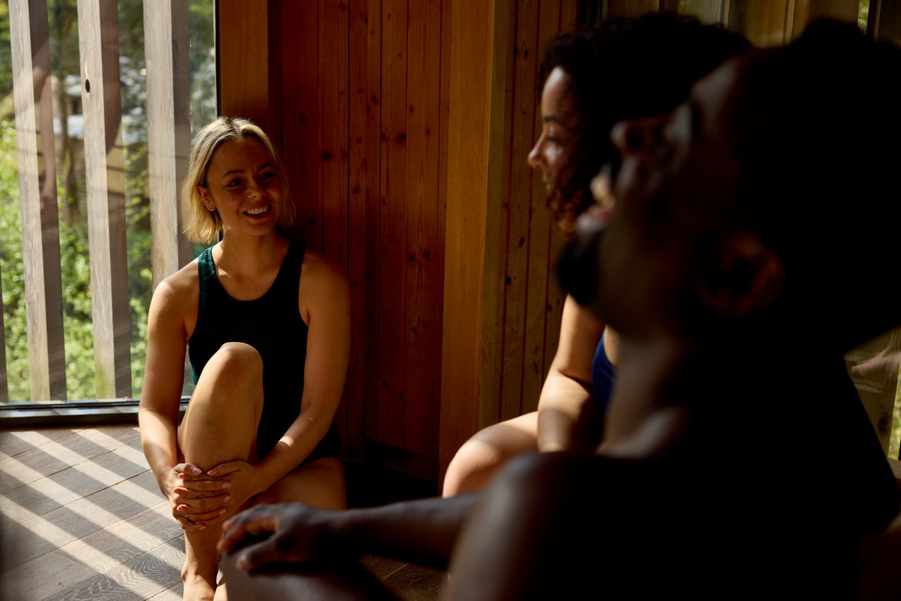 Group laughing as they socialise in a sauna.